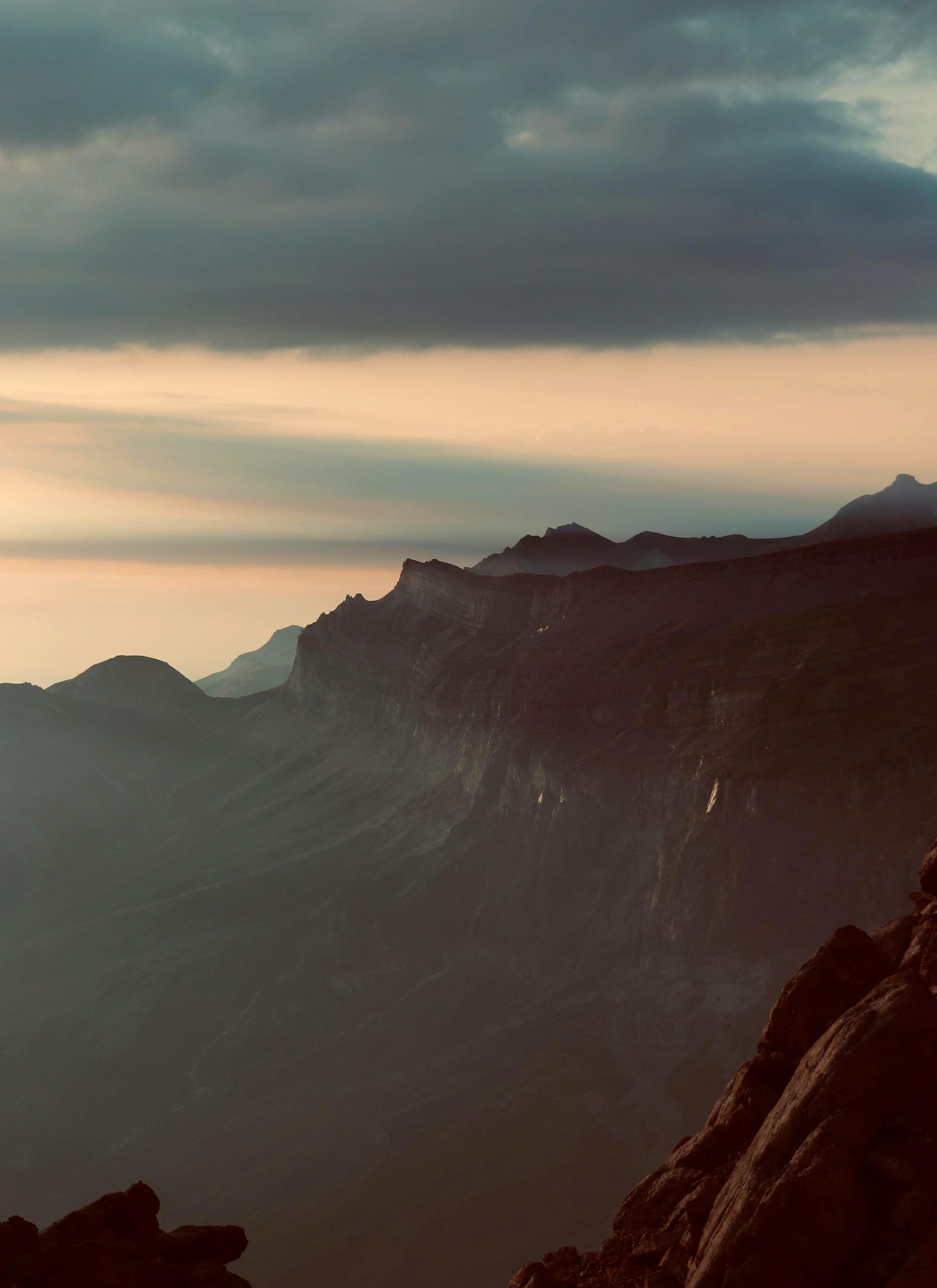 A traveller crossing a natural rock bridge high above a canyon